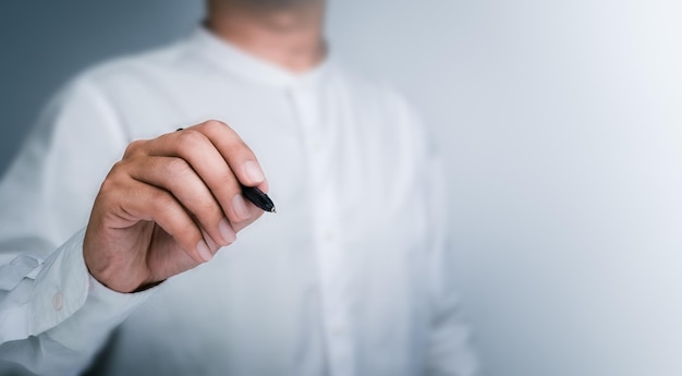 Schwarzer Stift in der Hand des Geschäftsmanns beim Zeichnen mit leerem auf weißem Hintergrund mit Kopierbereich Ein Mann, eine Person, schreibt etwas auf einem virtuellen Bildschirm