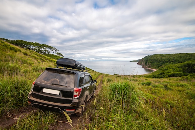 Schwarzer Subaru Forester mit Dachbox auf dem Weg hinunter zum Meer