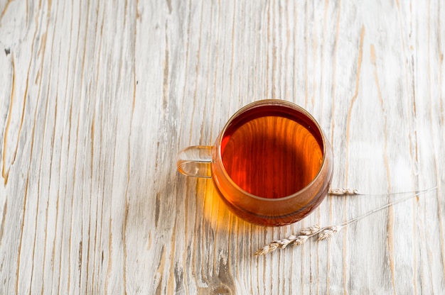 Schwarzer Tee in einer transparenten Tasse neben Spike