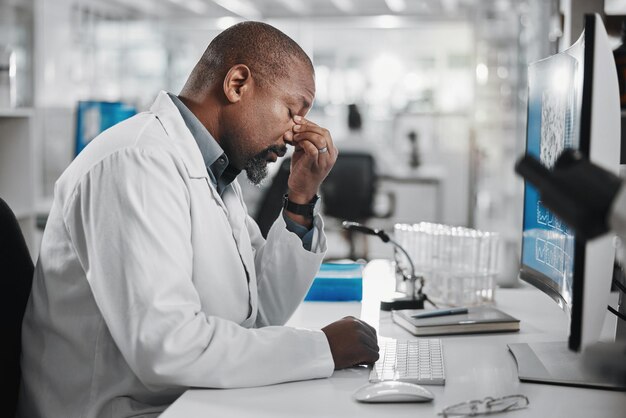 Schwarzer Wissenschaftler und Stress im Labor für Analyse, Innovation und medizinische Forschung Entwicklung von Technologie und professioneller Person oder Experte in der Klinik für Diagnose, Heilung und Kopfschmerzen