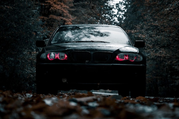 Schwarzes Auto auf dem Hintergrund von Bäumen