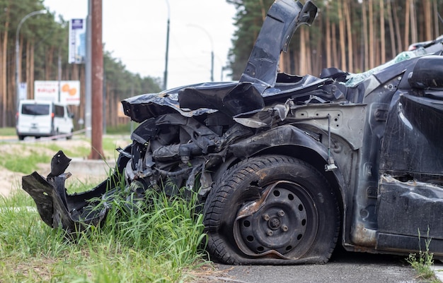 Schwarzes Auto nach einem schrecklichen Unfall am Straßenrand Frontal- und Seitenaufprall Lebensversicherung Ein Unfall ohne Heilungsmöglichkeit Seitenansicht Schaden nach einem Unfall