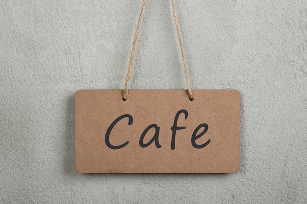 Schwarzes Brett, Schild, Tafel, Tafel mit Text Café an grauer Zementwand