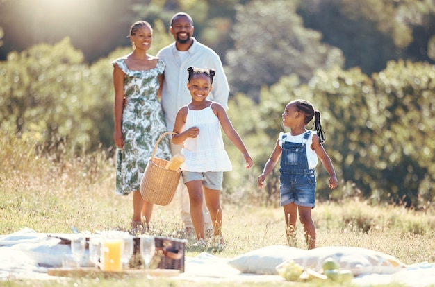 Schwarzes Familiensommerpicknick und Kinder verbinden sich mit Eltern in der Pause auf einem abgelegenen Landschaftsparkfeld Lächeln Sie glücklich und lieben Sie Mutter Vater oder verspielte und lustige Mädchen in der Natur mit Mann und Frau