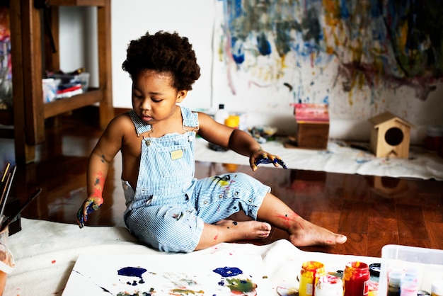 Schwarzes Kind, das seine Malerei genießt