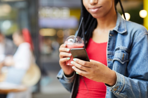 Schwarzes Mädchen, das Telefon überprüft