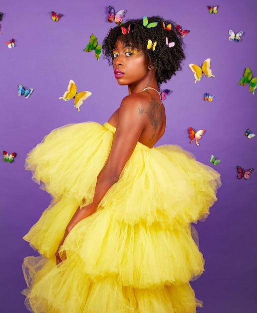 Foto schwarzes mädchen in gelbem tüllkleid mit schmetterlingen auf afro und schmetterlingen um sie herum