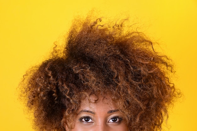 Foto schwarzes mädchen mit einer afro-frisur späht aus dem rahmen.