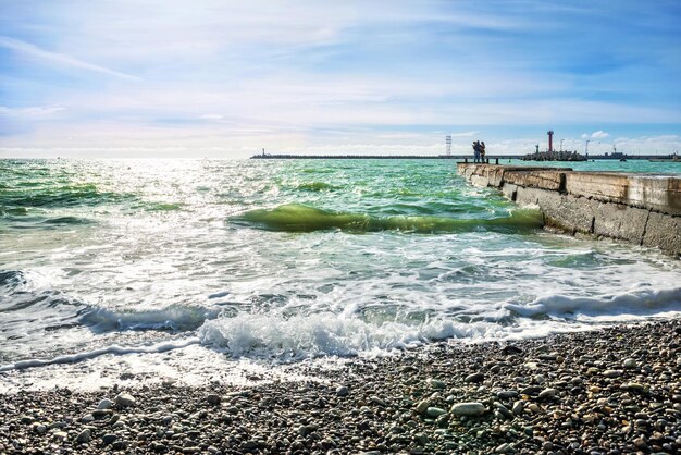 Schwarzes Meer von grüner Farbe mit Wellen und Steinen am Strand in der Stadt Sotschi