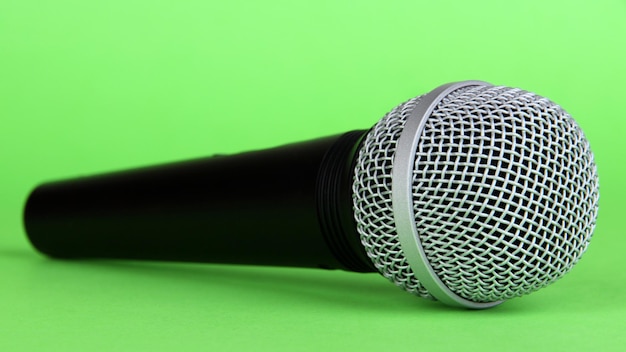 Schwarzes Mikrofon auf grünem Hintergrund