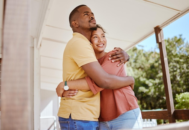 Schwarzes Paar, das sich verbindet und liebt, umarmt sich im Haus oder auf der Terrasse, wenn neue Immobilienbesitzer Hypothekeninvestitionserfolge oder Immobilienkäufer haben Lächeln Sie glücklich und umarmen Sie Mann und Frau mit zukünftigen Sicherheitszielen