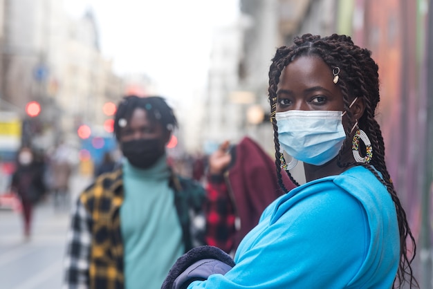 Schwarzes Paar in der Stadt. Mit Masken.