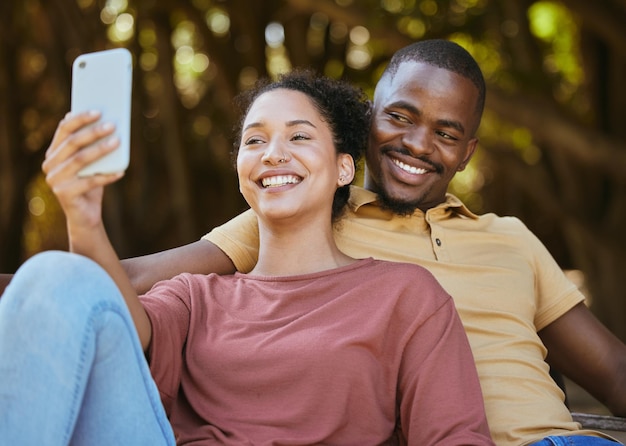 Schwarzes Paar Telefon und Selfie mit Lächeln im Outdoor-Naturpark für Reiseglück und Social-Media-Profilbild-Inhaltsaktualisierung Glücklicher Mann und Frau mit 5g-Netzwerkverbindung am Urlaubsdatum