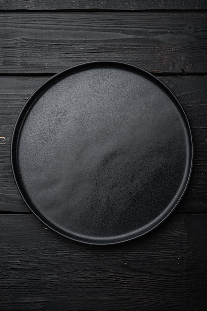 Schwarzes Plattenset, auf schwarzem Holztischhintergrund