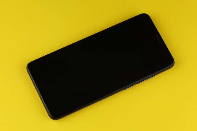 Schwarzes Smartphone auf farbigem Hintergrund