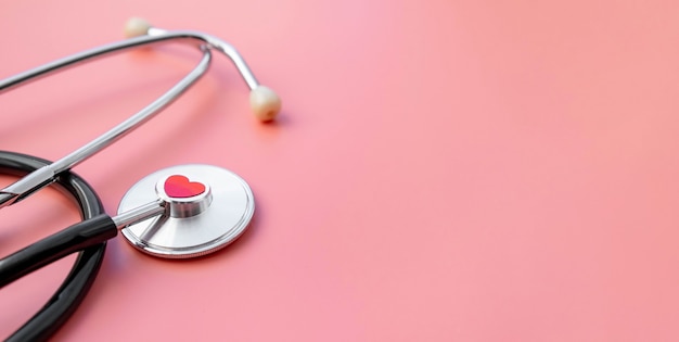 Schwarzes Stethoskop mit rotem Herz des Arztes zur Überprüfung auf rosa