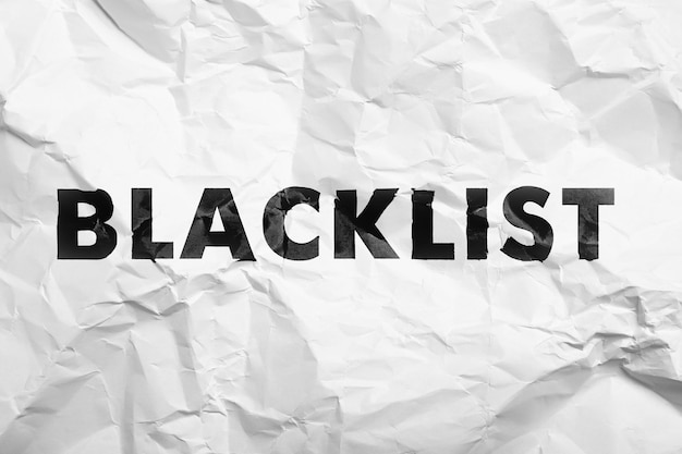 Schwarzes Wort Blacklist auf zerknittertem weißen Papier