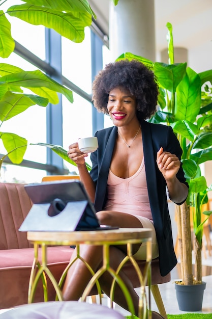 Schwarzhäutiges Mädchen mit Afro-Haaren, das ein rosa Kleid und eine schwarze Jacke trägt