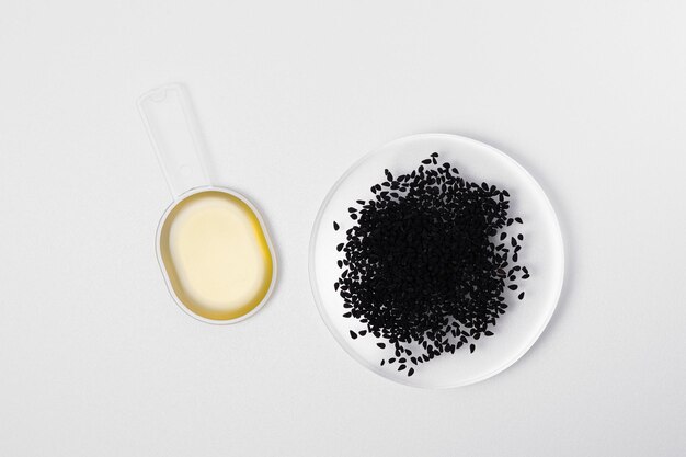 Schwarzkümmelöl in Löffel und Nigella Sativa oder Kalonji-Samen auf weißem, isoliertem Hintergrund Das Konzept der organischen Kräutermedizin für viele Krankheiten Bild für Ihr Design