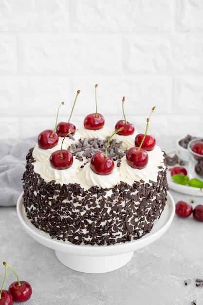 Schwarzwälder Kirschtorte, Schwarzwälder Torte. Kuchen mit dunkler Schokolade, Schlagsahne und Kirsche auf grauem Betonhintergrund. Platz kopieren.