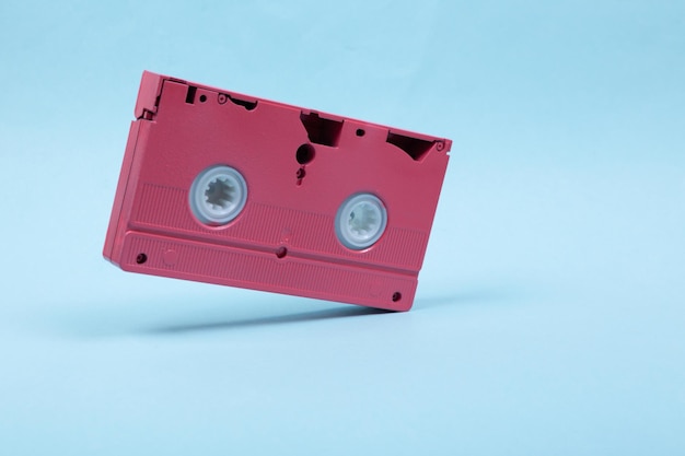 Schwebende rosa Videokassette auf blauem Hintergrund 3D-Foto Minimalistisches Stillleben Kreatives Layout Konzeptkunst