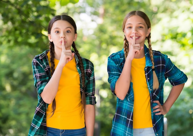 Schweigen ist Gold. Kleine Kinder legen Finger auf die Lippen. Stille-Konzept. Stillezeichen machen. Ganz solide Geste. Geheim oder vertraulich. Freunde und Freundschaft. Sommerurlaub. Den Mund halten.