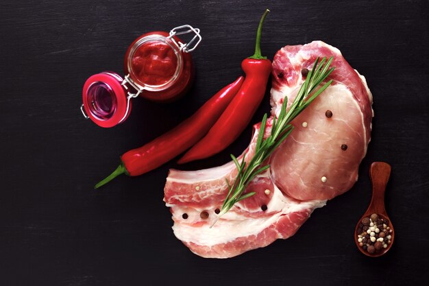 Schweinefleisch entrecote rohes Fleisch mit Rosmarin, Pfeffer und roter Sauce.