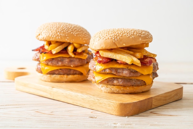 Schweinefleisch-Hamburger oder Schweinefleisch-Burger mit Käse, Speck und Pommes Frites