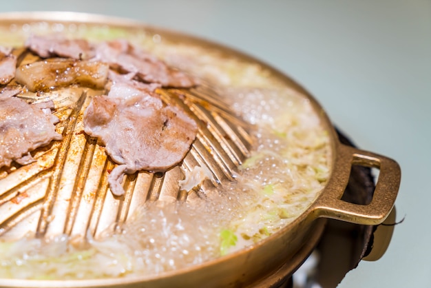 Schweinefleisch in Scheiben geschnitten auf der heißen Pfanne Grillen