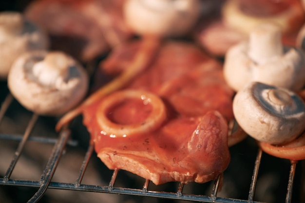 Schweinefleisch in Tomatensoße mit Zwiebelringen und Pilzen, die draußen auf dem Grill Grillen im Freien