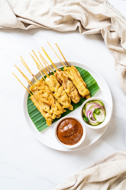 Foto schweinefleisch-satay - gegrilltes schweinefleisch, serviert mit erdnusssauce oder süß-saurer sauce