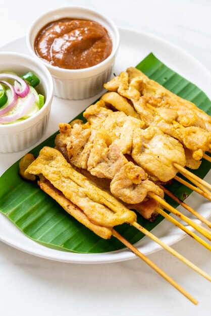 Schweinefleisch-Satay - Gegrilltes Schweinefleisch, serviert mit Erdnusssauce oder süß-saurer Sauce