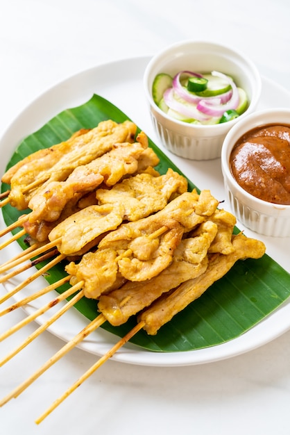 Schweinefleisch-Satay - Gegrilltes Schweinefleisch, serviert mit Erdnusssauce oder süß-saurer Sauce