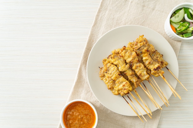 Schweinefleisch-Satay mit Erdnusssauce Gurkenscheiben und Zwiebeln in Essig - asiatische Küche