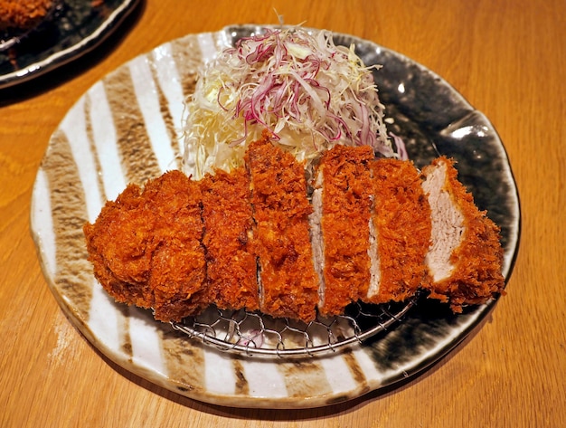 Schweinefleisch Tonkatsu oder japanisches frittiertes Schweinefleisch mit knusprigen Brotkrumen auf Holztisch