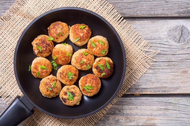 Schweinefleischbällchen mit Petersilie in der Pfanne von oben