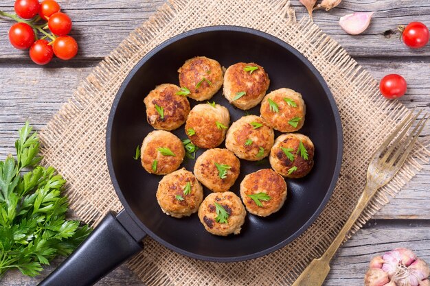 Schweinefleischbällchen mit Petersilie in der Pfanne von oben