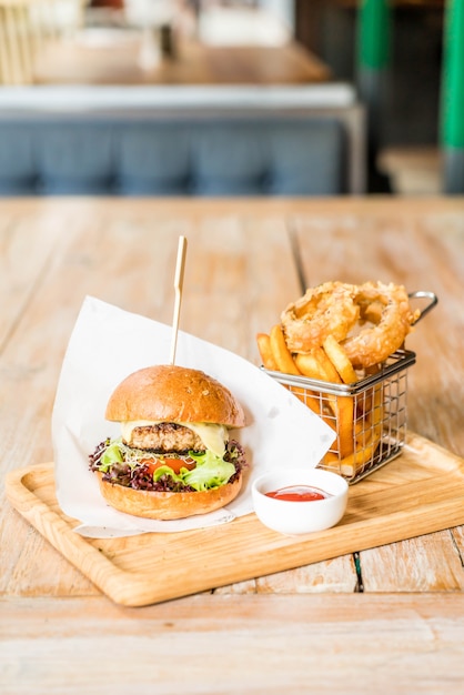 Schweinefleischburger mit Zwiebelringen und Pommes Frites