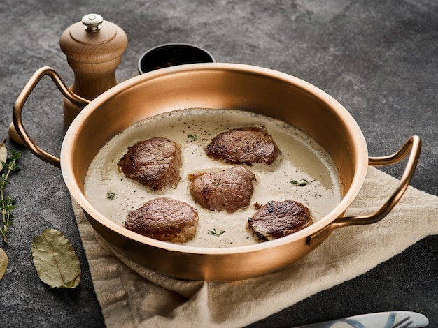 Schweinefleischmedaillons mit Sahnesauce in der Pfanne