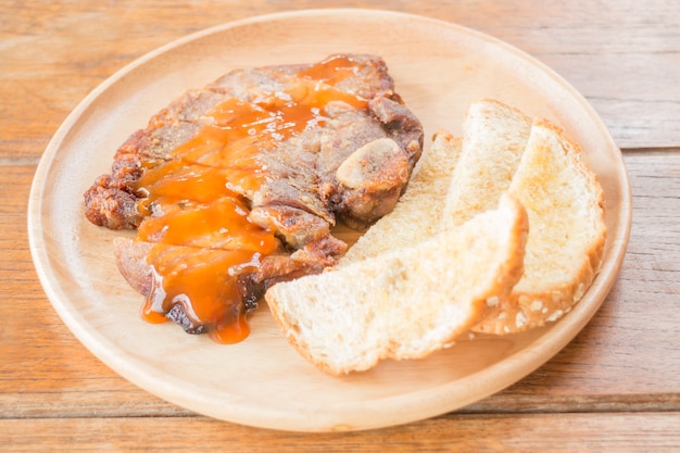 Schweinefleischsteak auf hölzerner Platte