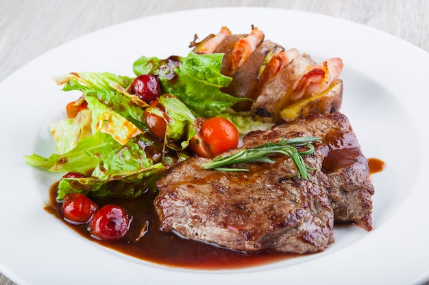 Schweinegulasch in Sauce mit Salat und Ofenkartoffeln