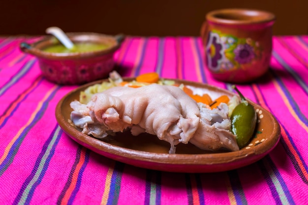 Schweinekeule mit Essig auf einem Tonteller, typisch mexikanisches Essen