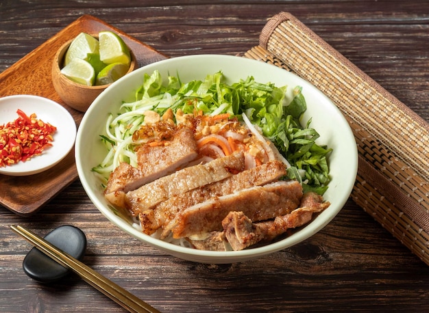 Schweinekoteletts mit vietnamesischen Reisnudeln, serviert in einer Schüssel, isoliert auf dem Tisch mit Blick auf taiwanesisches Essen