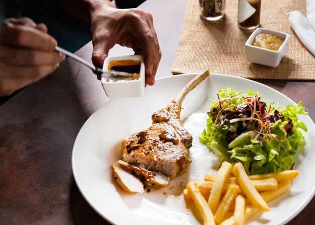 Schweinekotelettsteak mit Salat und Pommes Frites