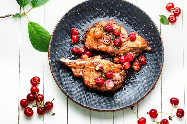 Foto schweinesteak am knochenbraten in beerenmarinade.fleisch in kirschweinsauce