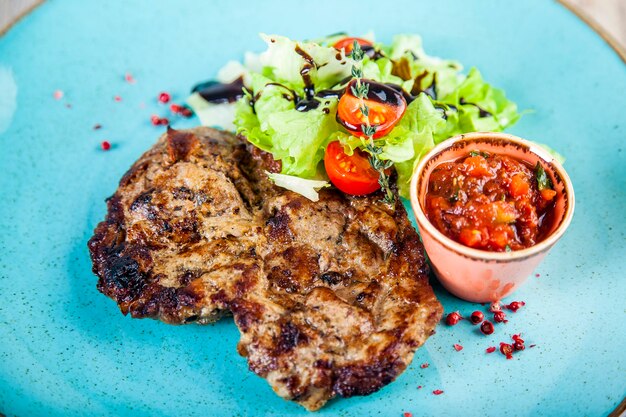 Schweinesteak mit Tomaten-Scharf-Sauce und Salat