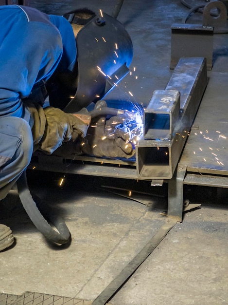 Schweißarbeiten mit Geräten für Stahl-Metall-Eisen-Funken in der Schwerindustrie-Fabrik im Innenbereich