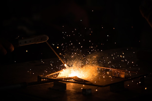 Foto schweißen, metallbearbeitung auf dunklem hintergrund