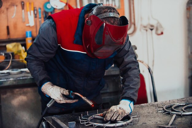 Schweißer, der technischen Stahl aufrichtet Industrieller Stahlschweißer in der technischen Fabrik