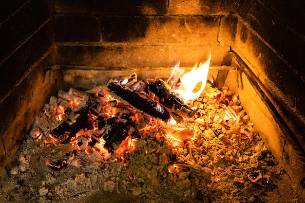 Schwelendes Brennholz und heiße Asche im Kamin